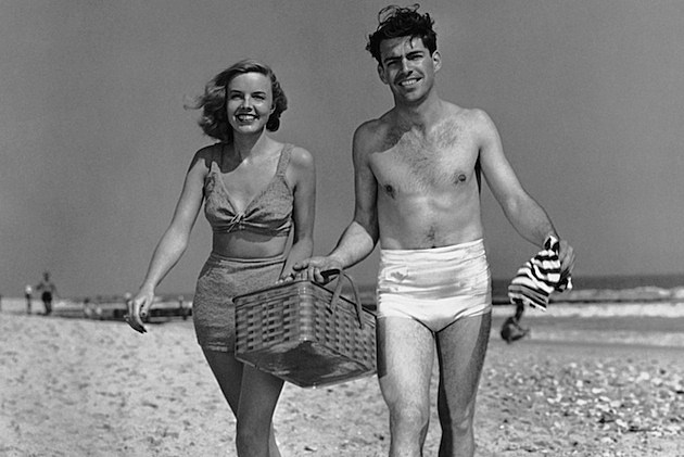 Couple walking with picnic basket on beach Couple walking with picnic basket on beach